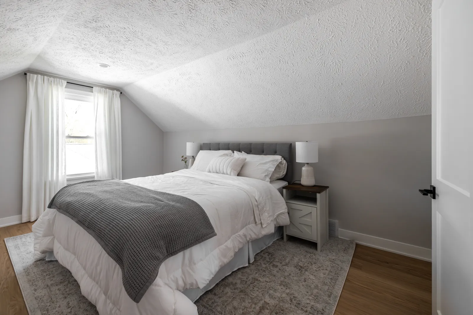 Finished bedroom with new flooring, paint, and staging